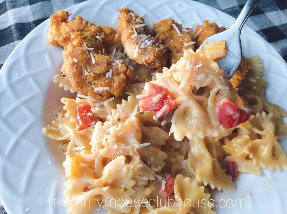 A bowl of Cheesecake Factory's Louisiana Chicken Pasta with a close up of Pasta on a fork.
