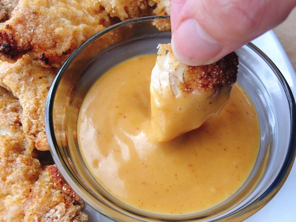 Chicken being dipped into Copycat Chick-fil-a Sauce