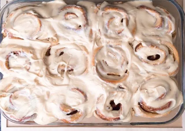 Butter Pecan Cake Mix Cinnamon Rolls with Salted Caramel Glaze in a baking dish.
