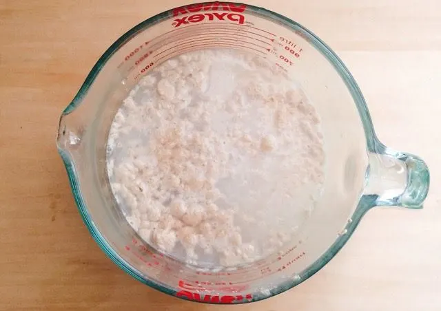 Measuring cup of yeast and water for Cake Mix Cinnamon Rolls