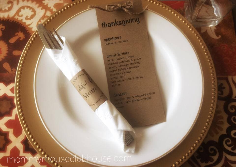 A Thanksgiving menu on a plate with silverware.