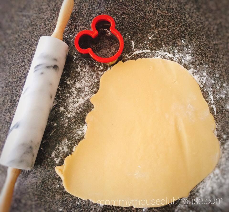 The BEST Sugar Cookie Recipe dough rolled out with a rolling pin and Mickey Mouse cookie cutter.