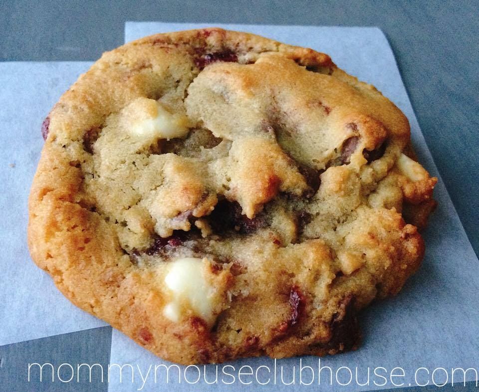 A Raspberry White Chocolate Chip Cookie on parchment paper