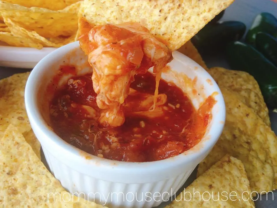 A chip dipped in Homemade Restaurant Style Salsa with cheese.