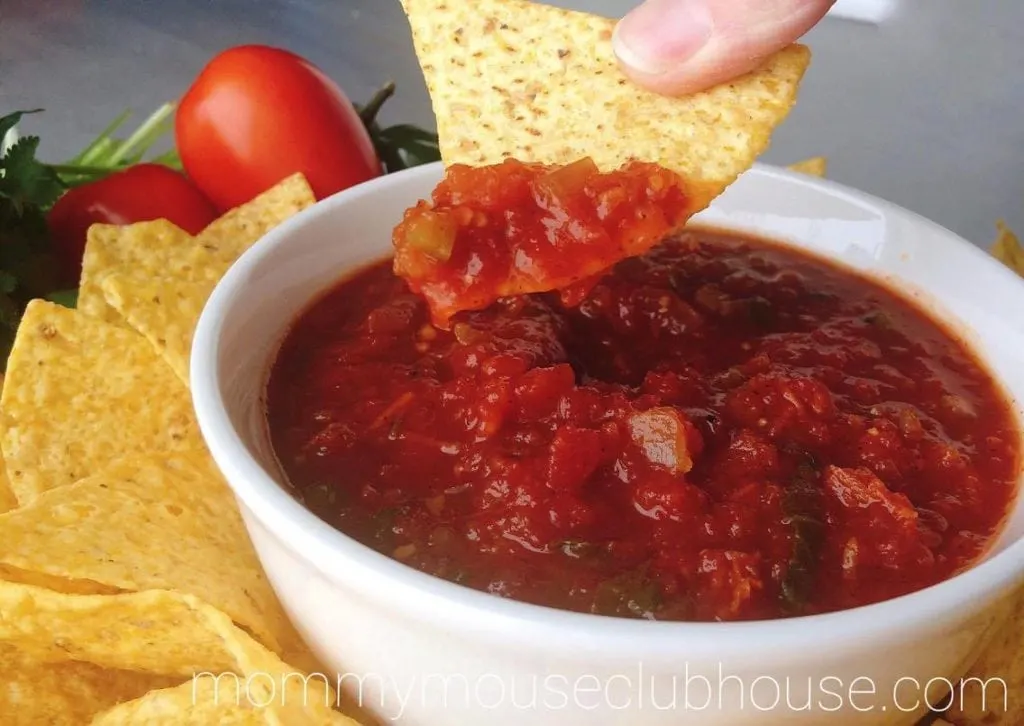 A tortilla chip dipped into Homemade Restaurant Style Salsa.