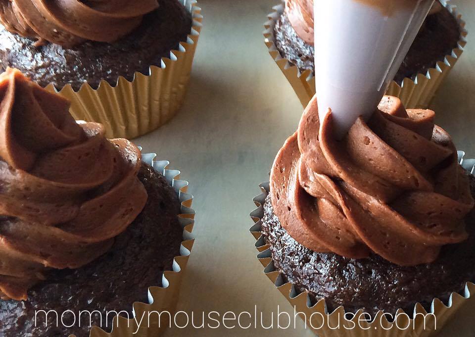 Frosting being piped onto Chocolate Salted Caramel Cupcakes