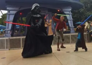 Darth Vader fighting a boy with light sabers during Jedi Training at Disneyland