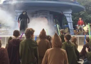 Kylo Ren on a stage with fog talking to kids with light sabers at Jedi Training at Disneyland