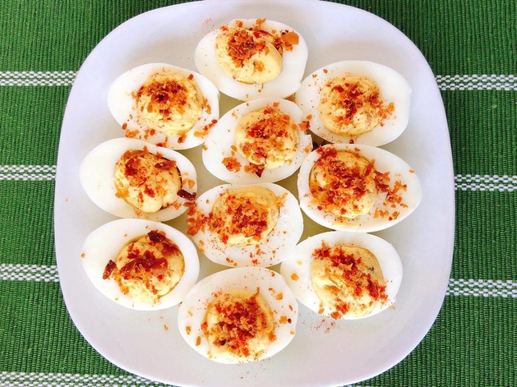 Crack Deviled Eggs on a plate over a green background