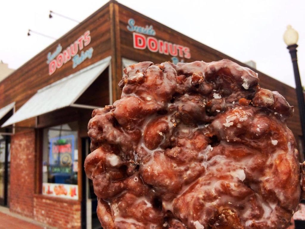 An apple fritter in from of Seaside Donuts Bakery in Newport Beach California
