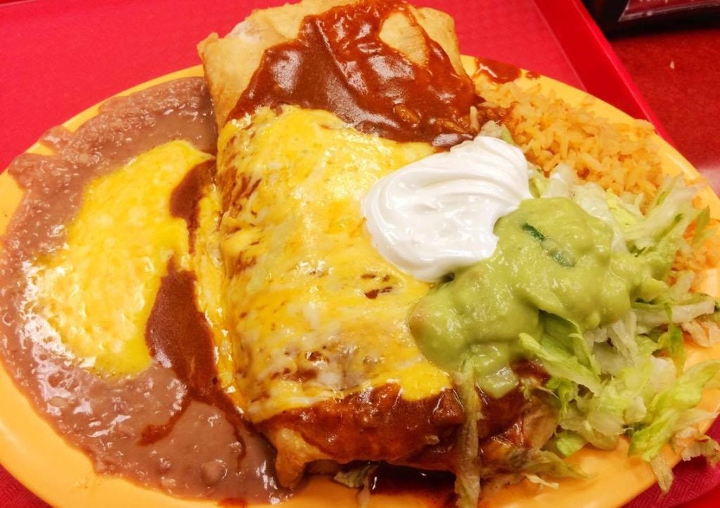 Chicken Chimichanga with rice, beans, lettuce, sour cream, and guacamole.