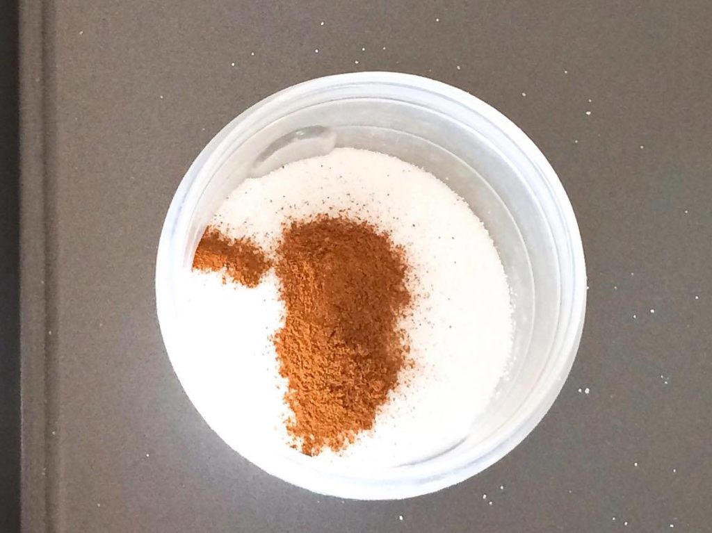 Cinnamon and sugar in a bowl on a baking sheet to make Homemade Disney Churros.