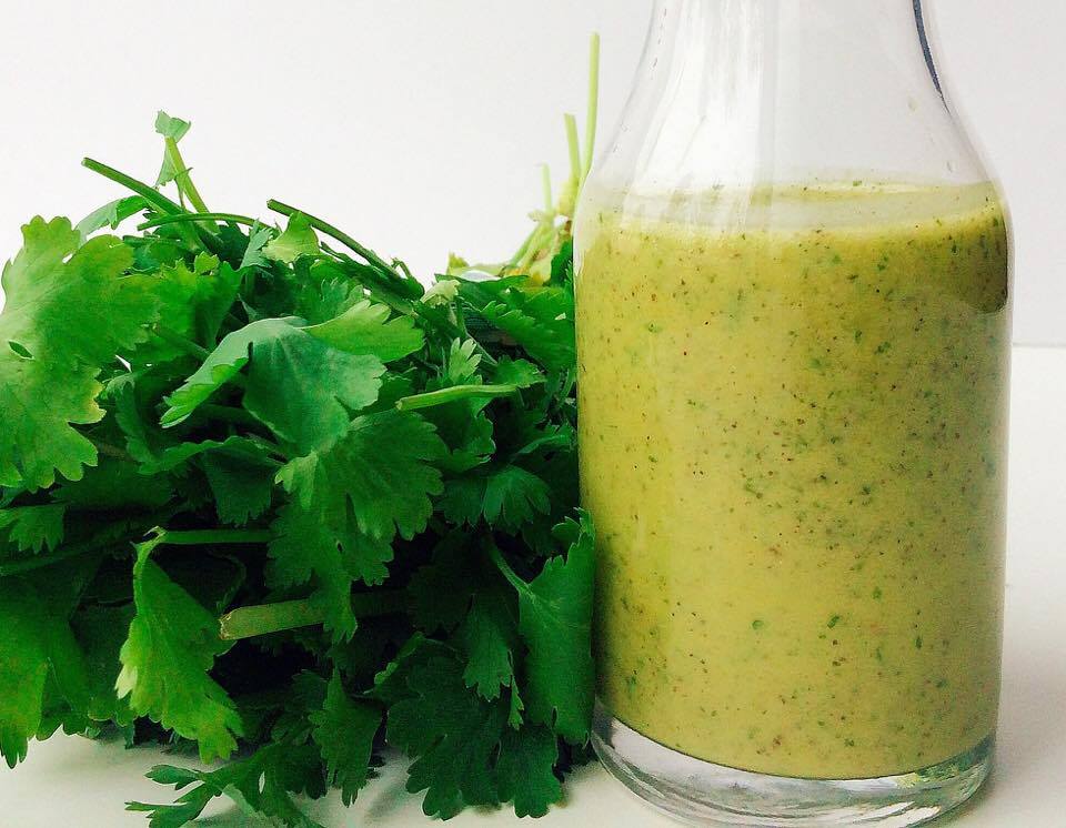 Fresh herbs next to a jar of homemade Herb Vinaigrette to make a Cobb salad.