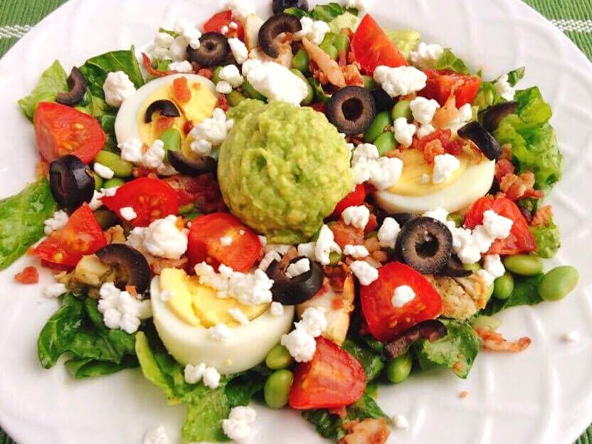 A copycat Zupas California Protein Cobb Salad with lettuce, tomatoes, olives, hard boiled eggs, avocado, and feta cheese.