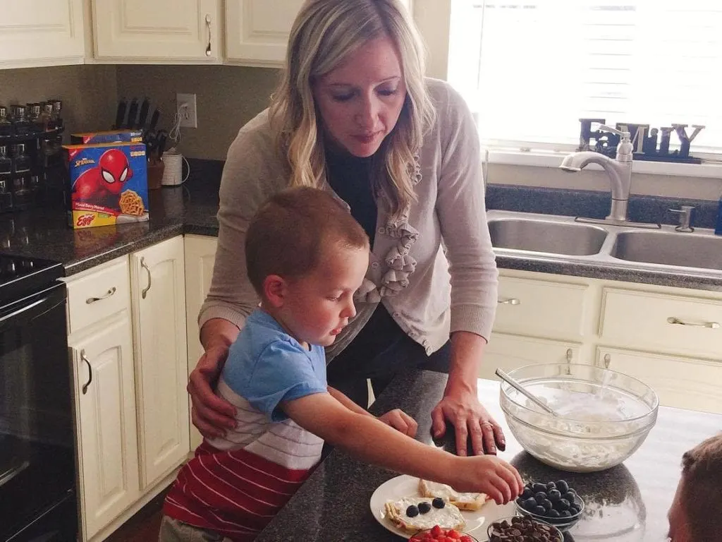 A mom and son putting berries on a Grilled Sweet Berry Waffle Sandwich