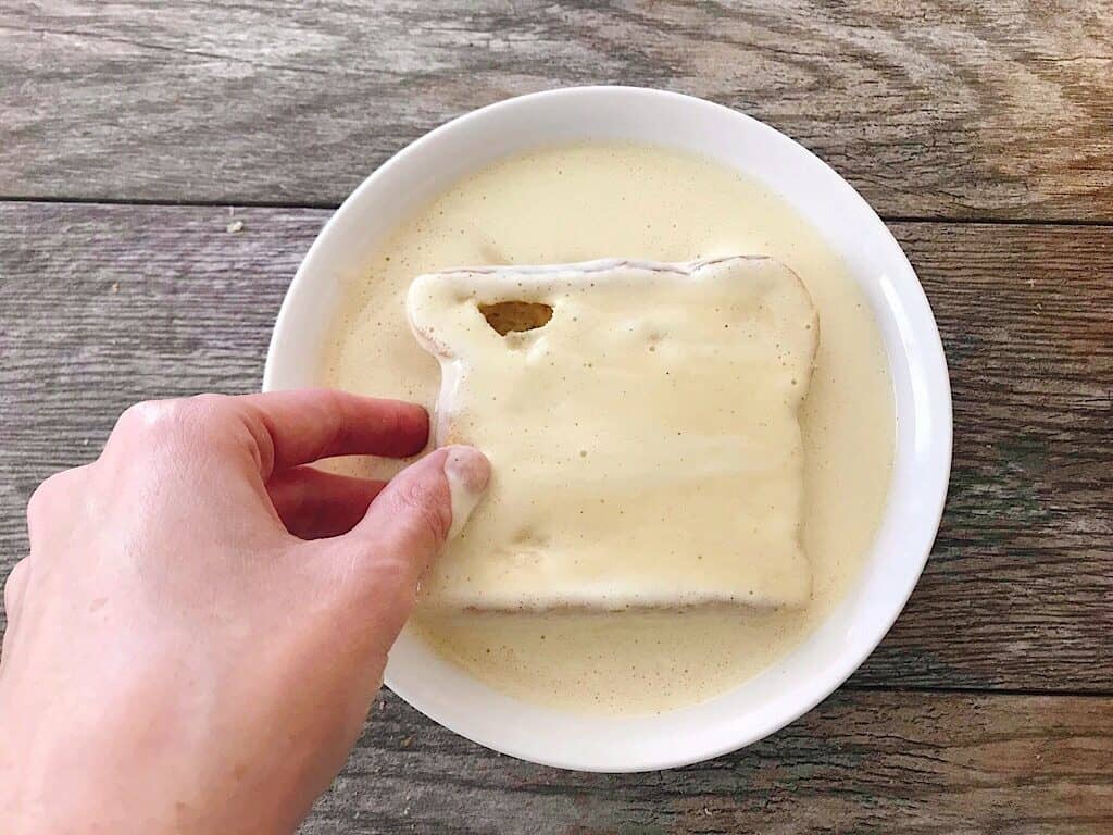 A slice of bread dipped into French Toast Batter