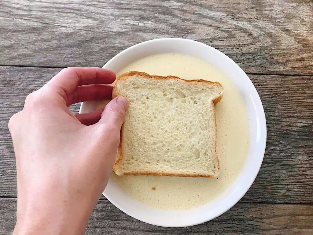 A slice of bread dipped into French Toast Batter