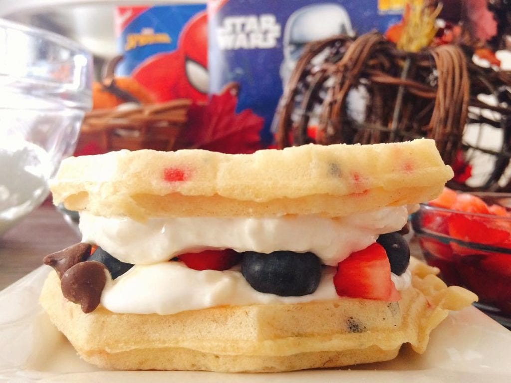 A Grilled Sweet Berry Waffle Sandwich in front of Eggs Waffle boxes