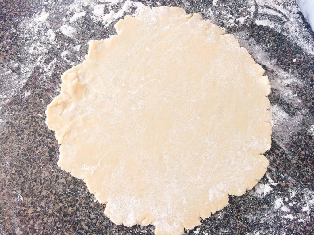 Rolled out pie crust for Rustic Apple Pie, surrounded by flour