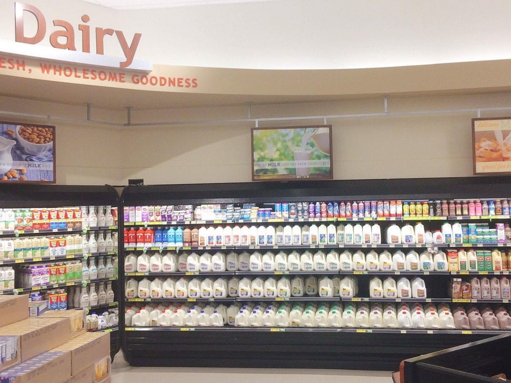 Dairy section of a grocery store with shelves of milk and other dairy products
