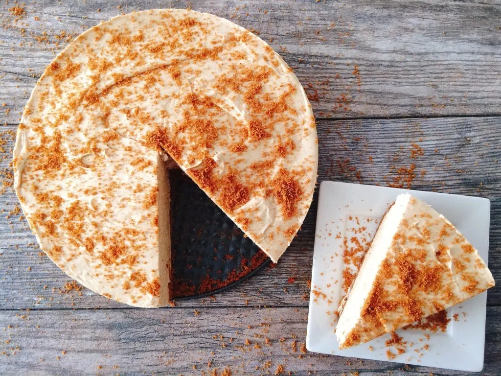 Cookie Butter No Bake Cheesecake with a slice cut out on a white plate