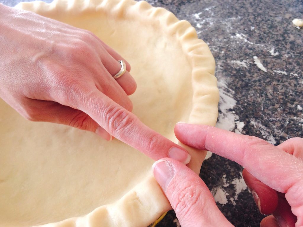 Hands shaping a Flaky All-Butter Pie Crust.
