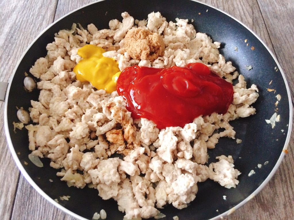 Ground turkey with ketchup and mustard in a pan