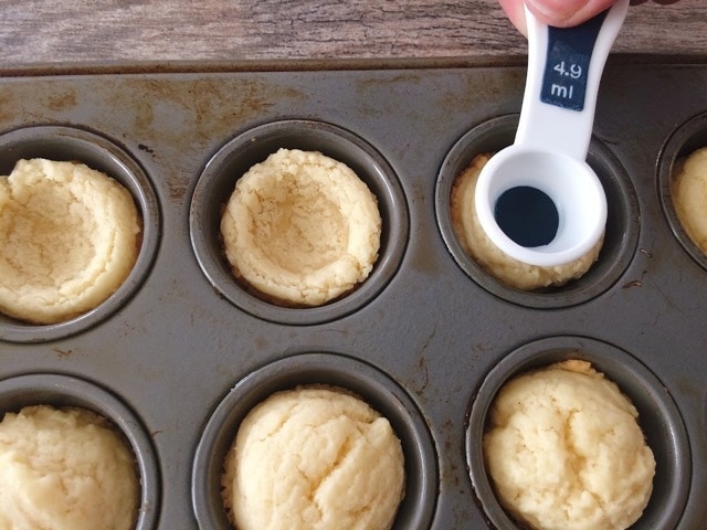 Spoon indenting an Easter sugar cookie in a muffin pan