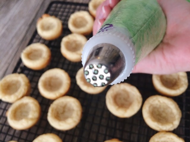 Frosting in a piping bag over Easter sugar cookie cups