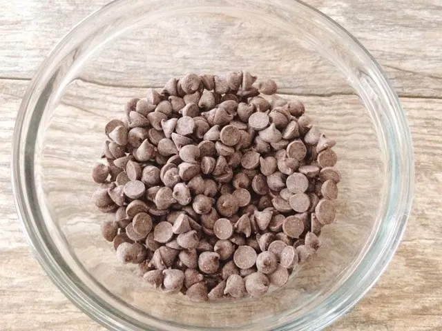 A glass bowl of chocolate chips.