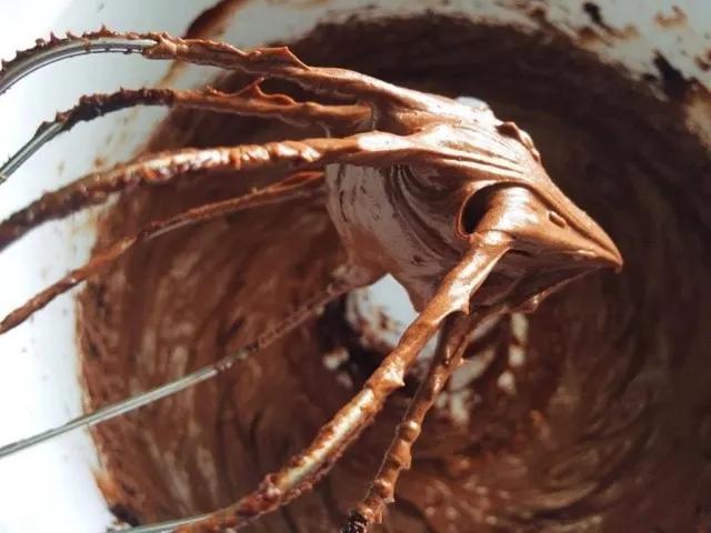 Whipped chocolate ganache on a whisk.