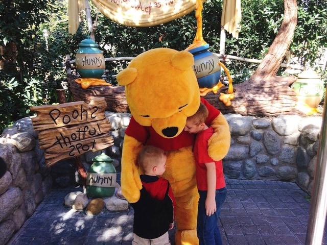 Winnie the Pooh giving two boys a hug at Disneyland. Helping them deal with Disney Withdrawl.