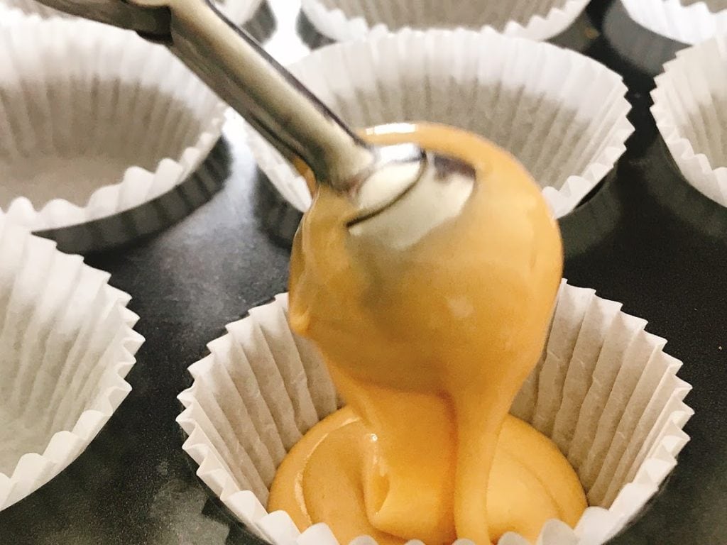 Butterbeer Cupcake batter being scooped into a cupcake liner.