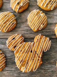 A Mickey Mouse shaped Soft Pumpkin Chocolate Chip Cookie drizzled with white chocolate.
