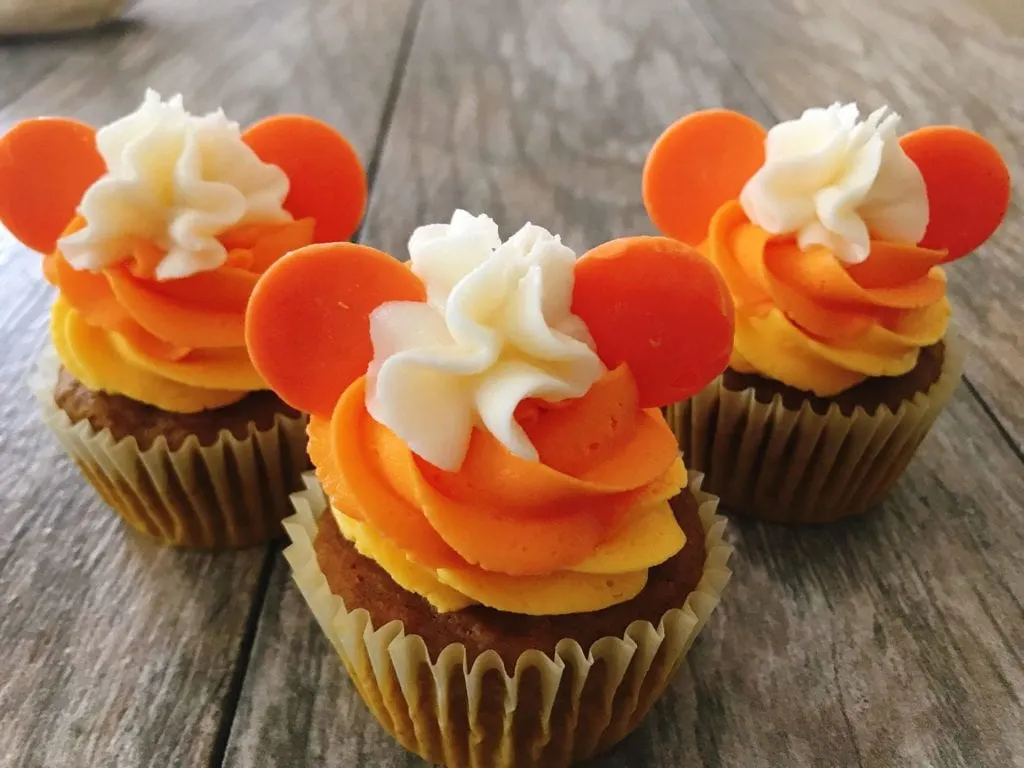 Three cupcakes decorated to look like Mickey candy corn Halloween Cupcakes.