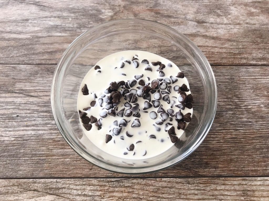 A bowl of chocolate chips and heavy cream to make the chocolate layer of a Caramel Pecan Silk Pie.