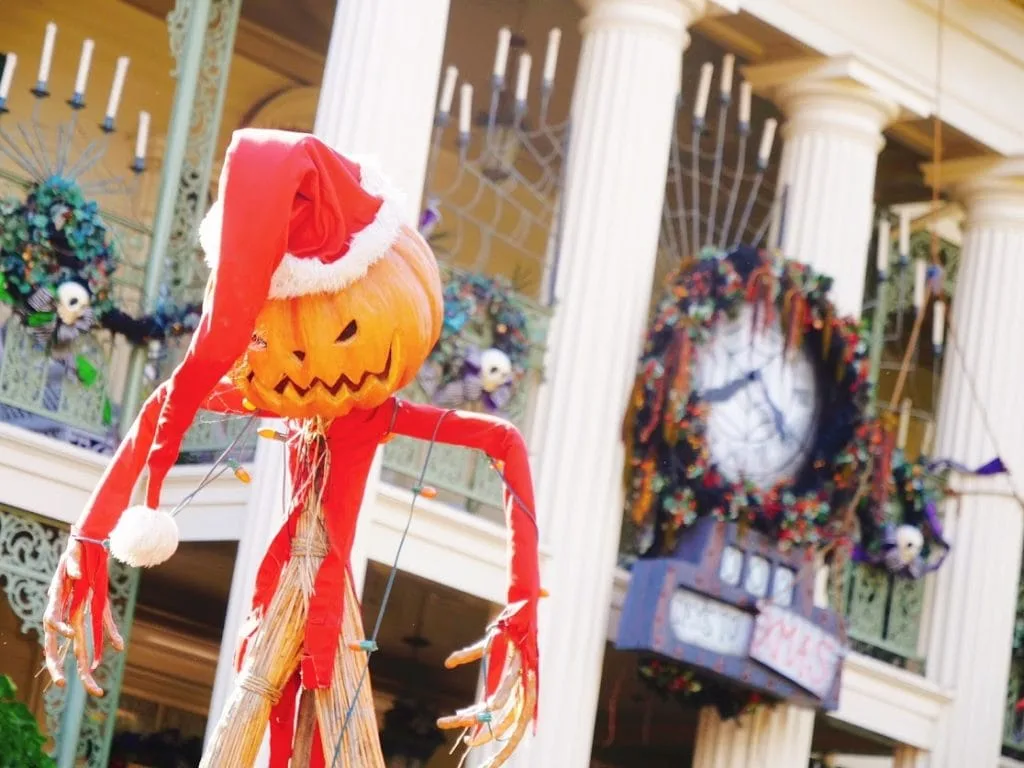 Jack the Pumpkin King in a Santa hat in front of Haunted Mansion Holiday for Christmas at Disneyland.