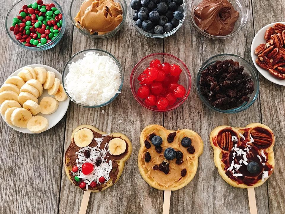 Waffle bar toppings bowls and three decorated Mickey Waffles to make a Mickey Mouse Waffle Bar