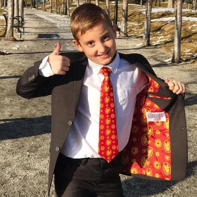 A boy wearing an Iron-Man themed suit giving a thumbs up.