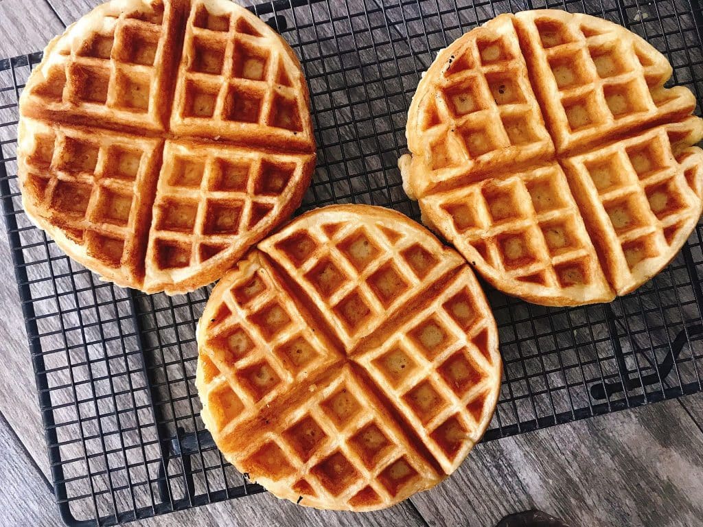 Three waffles on a cooling rack.