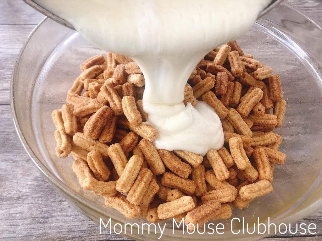 Marshmallow cream being poured into a bowl of Cinnamon Toast Crunch Churros.