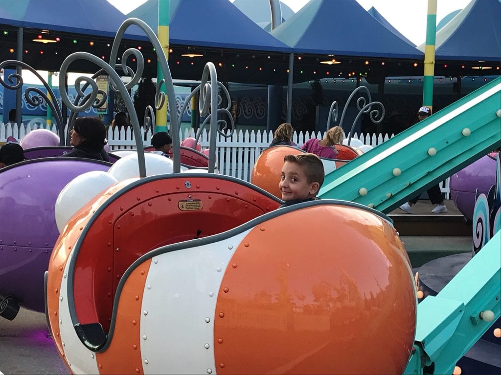 A boy riding in a large orange bug at Universal Studios Hollywood.