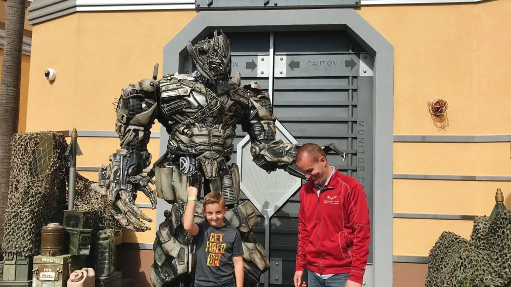 A large Transformer suit with a man and a child.