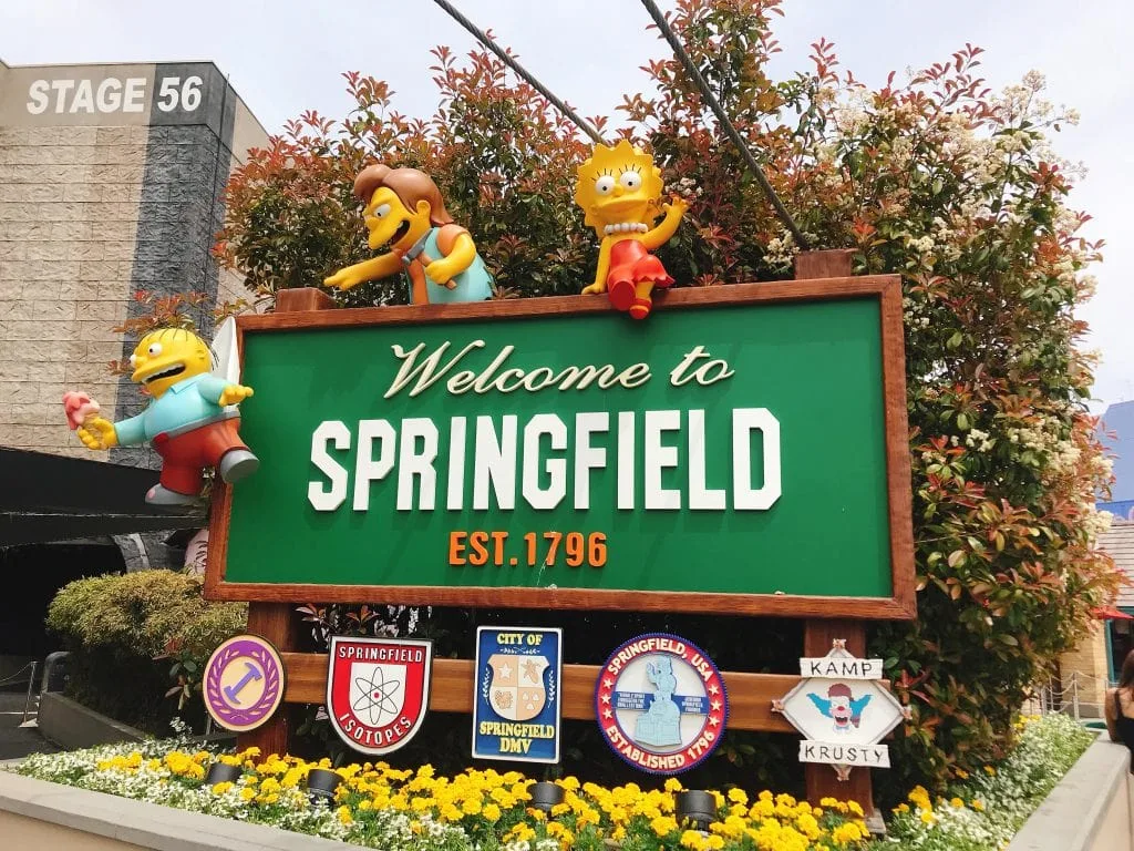 A sign with characters from The Simpsons that says, “Welcome to Springfield”