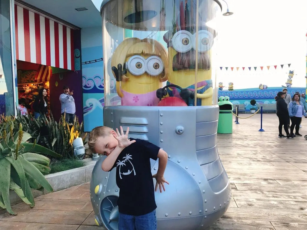 A child posing in front of Minions from the Despicable Me movies at Universal Studios Hollywood.