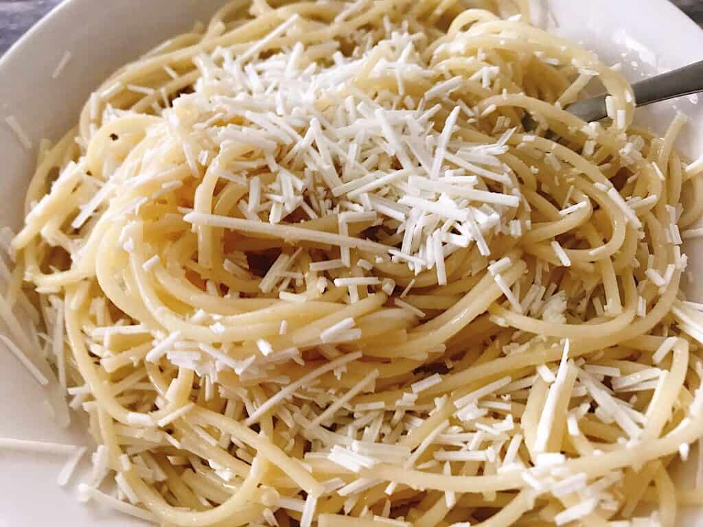 A bowl of spaghetti topped with browned butter and Mizithra cheese.
