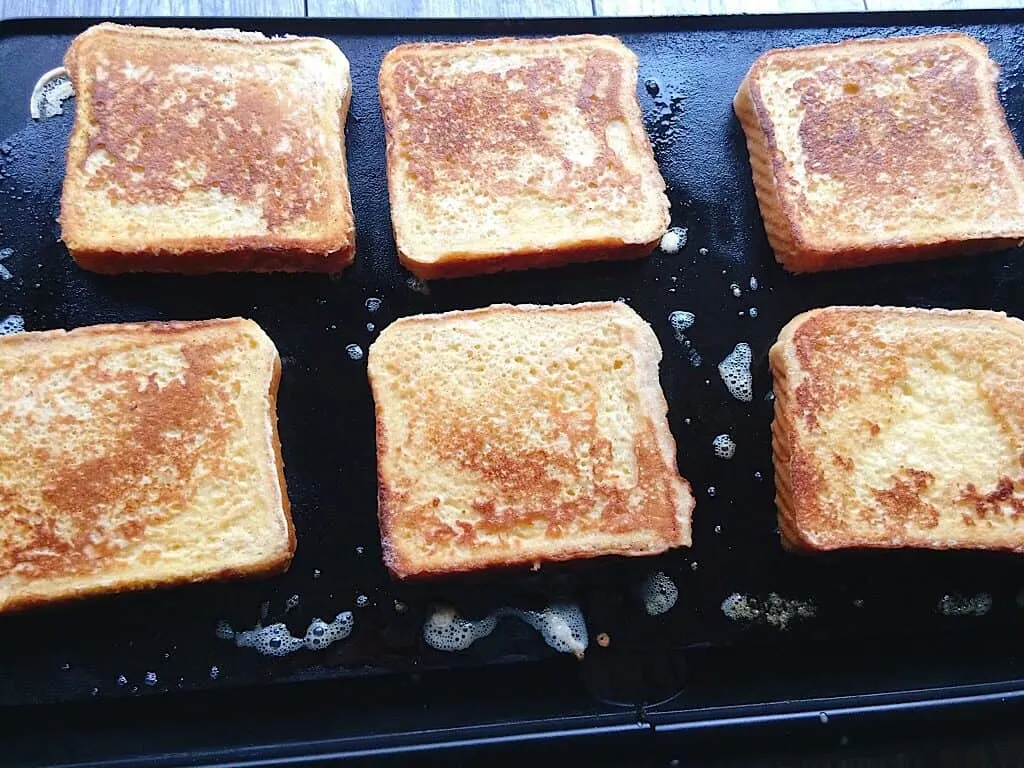 Slices of French Toast on a grill.