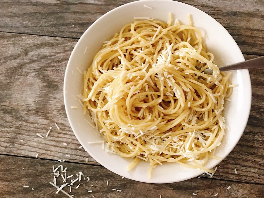 A fork in a bowl of browned butter spaghetti with Mizithra cheese.