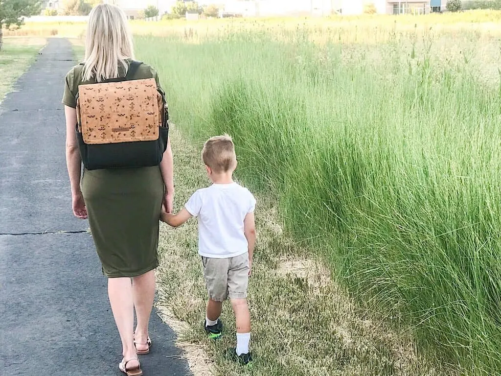 A woman with a backpack and her son walking on a path