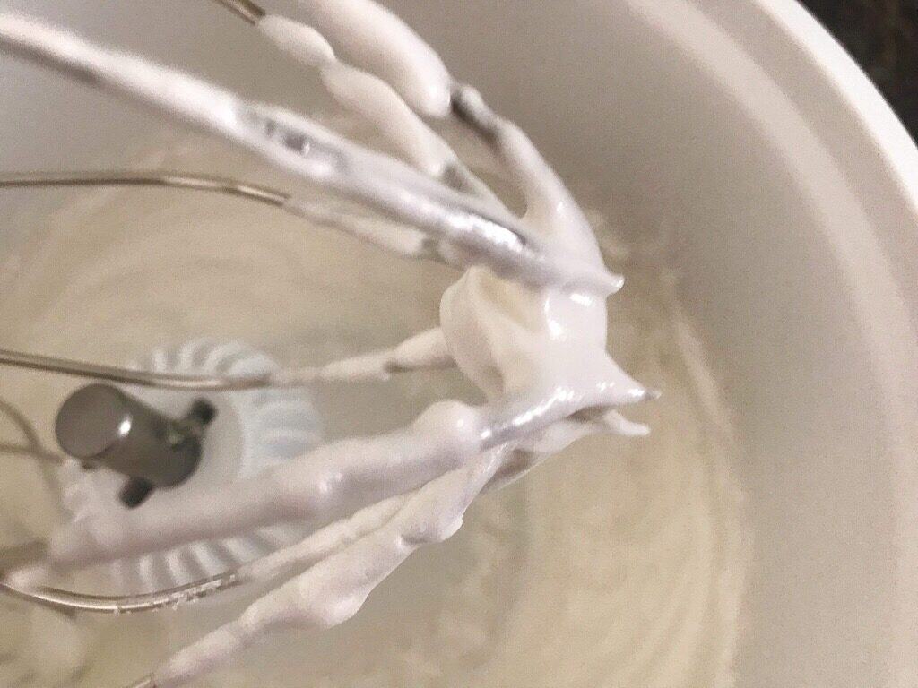 Whipped egg whites on a whisk to make crispy waffle batter.